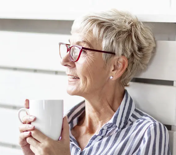 Older women with cup of tea or coffee enjoying natural light